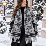Light grey blanket wrap with black distressed print and black striped borders worn over a black outfit