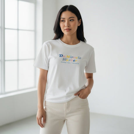 Woman wearing a white tshirt with colorful text in a bright room
