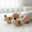 Ivory fleece cuffed baby booties with a puppy face, floppy tan ears and a black pompom nose