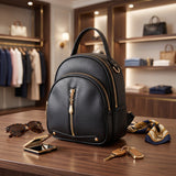 Black dome mini backpack with gold zip pulls and foot studs