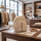 Cream dome mini backpack with a curved front zip pocket