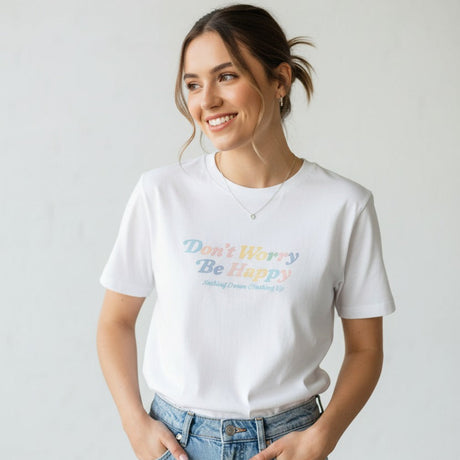 Woman wearing a white tshirt with colorful text and blue jeans against a plain background