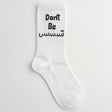 White ribbed crew sock with a Don't Be slogan in black English and Arabic lettering