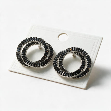 Pair of black double circle baguette crystal earrings on a white display card
