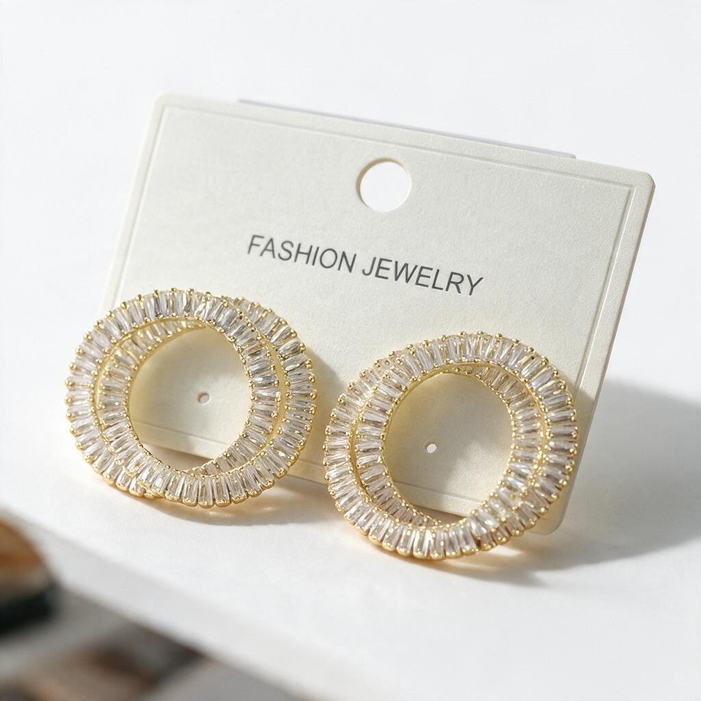 Gold double ring earrings lined with clear baguette crystals on a white card