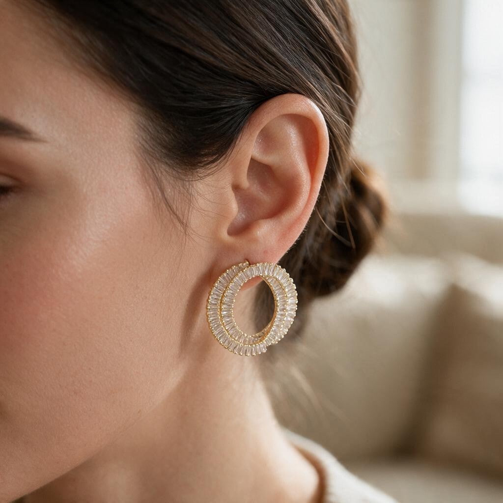 Gold double circle earring with clear baguette crystals worn on the ear