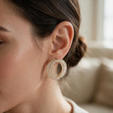 Gold double circle earring with clear baguette crystals worn on the ear