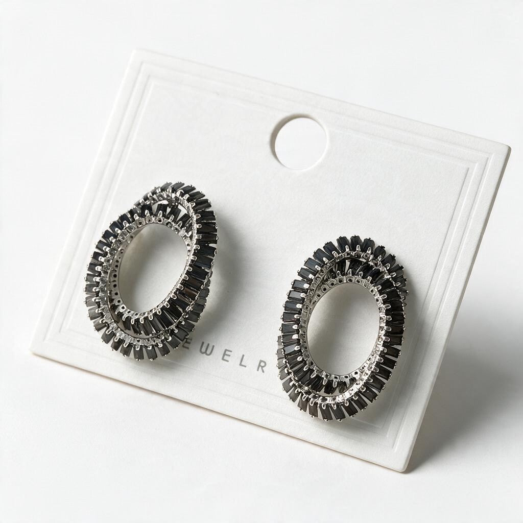 Pair of black double oval baguette crystal earrings on a white display card