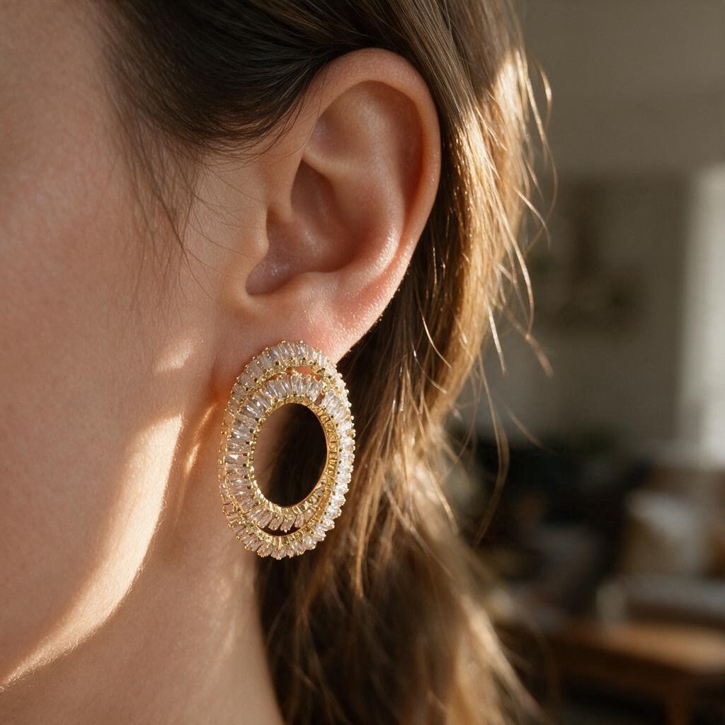 Gold double oval earring with clear baguette crystals in warm sunlight