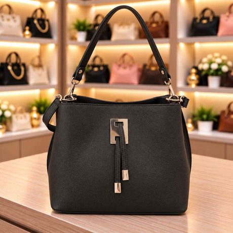 Black bucket bag with a silver clasp and double tab front, a top handle and a matching strap