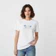 Woman wearing a white tshirt with colorful "During Waves" text on a plain background