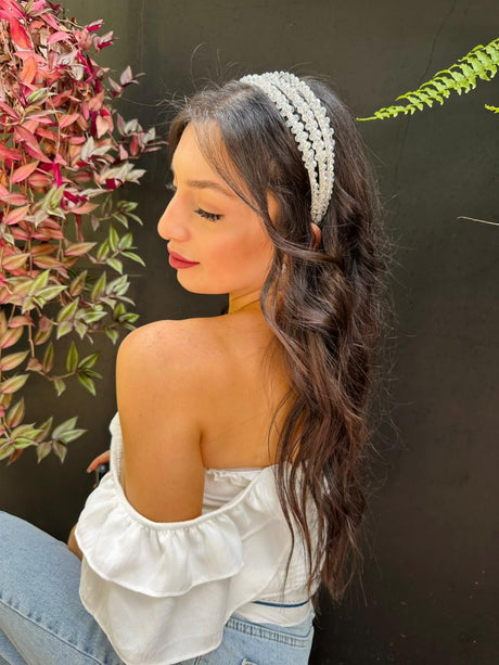 Woman wearing a white elegant bloom headpiece with plants in the background
