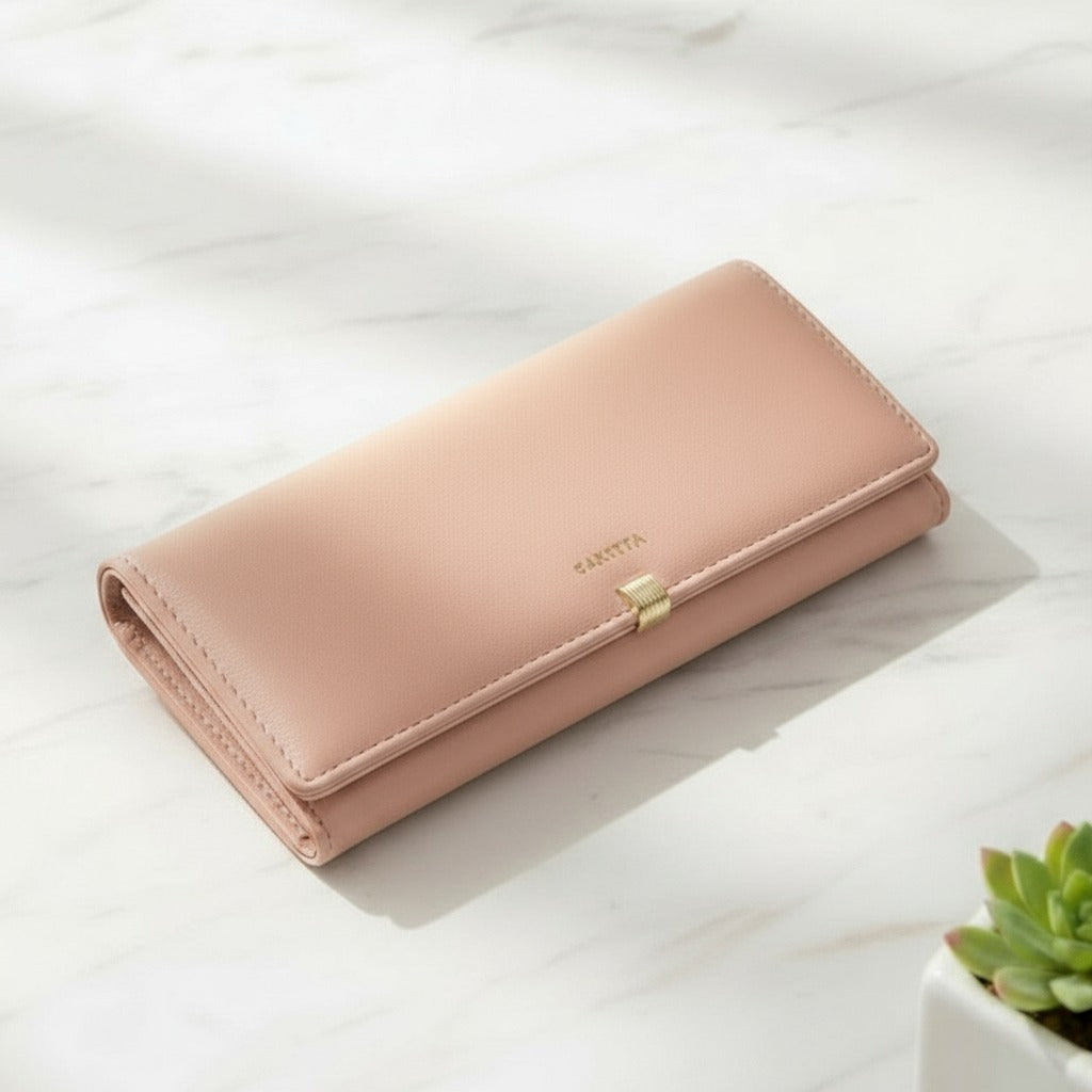 Pink wallet on a light surface with a plant in the corner