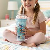 Girl sitting on a bed holding an ice blue elephant print cup with a bead dome lid