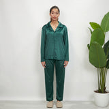 Full length emerald green velvet pajama set worn with cream slippers