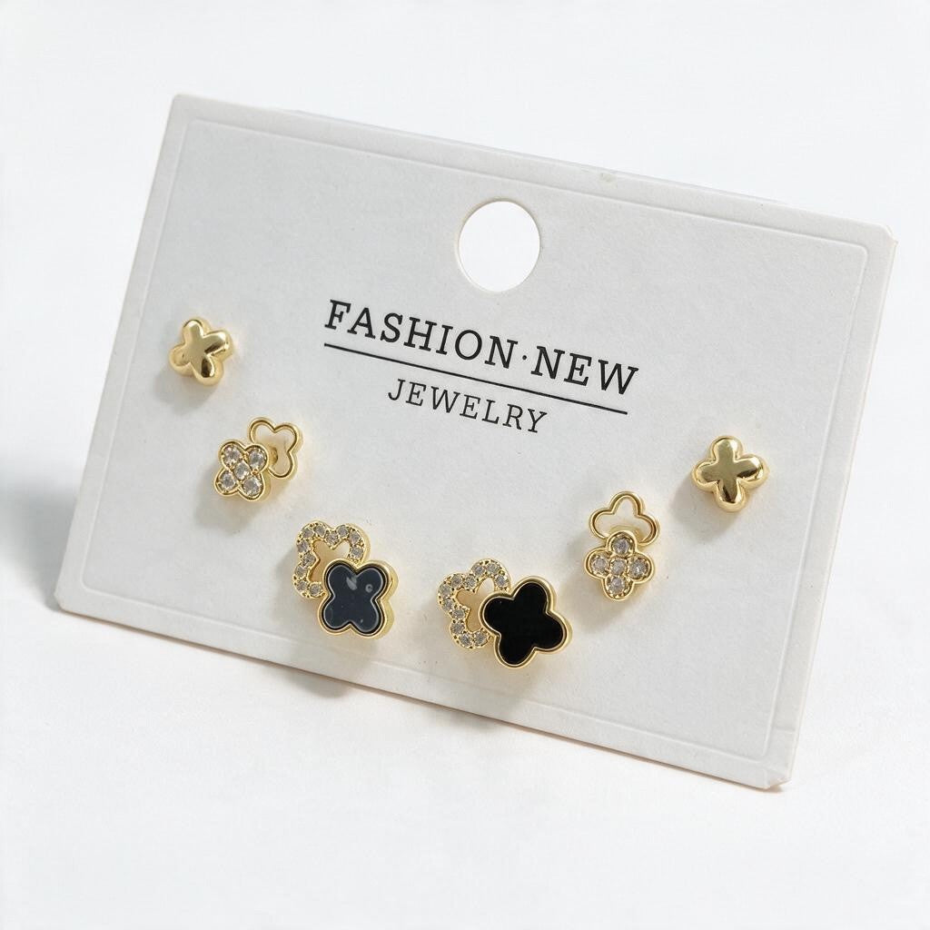 Gold tone clover stud set with polished crosses, pave flower outlines and black enamel clovers