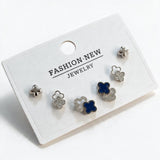 Silver tone clover stud set with polished crosses, pave outlines and navy enamel clovers on a card
