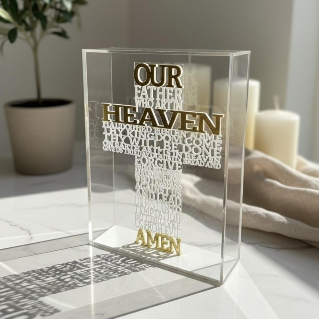 The English prayer raised in white on a clear block, its shadow cast across marble