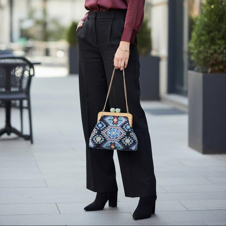 Ethnic pattern handbag carried with black wide leg trousers on a city pavement