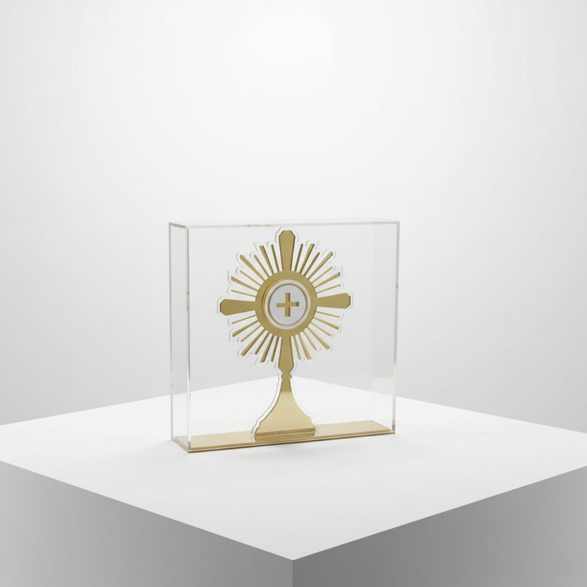 Rayed gold monstrance with a frosted host disc standing in a clear acrylic case