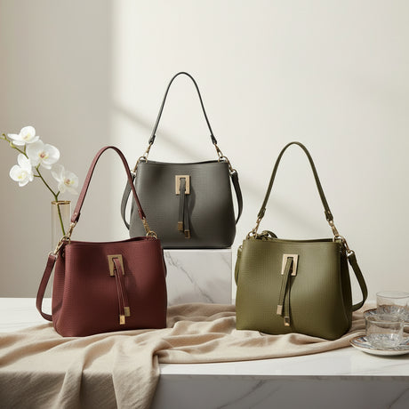 Structured bucket handbag with a gold bar clasp shown in burgundy, grey and olive