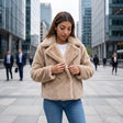 Camel faux fur coat buttoned on a city street