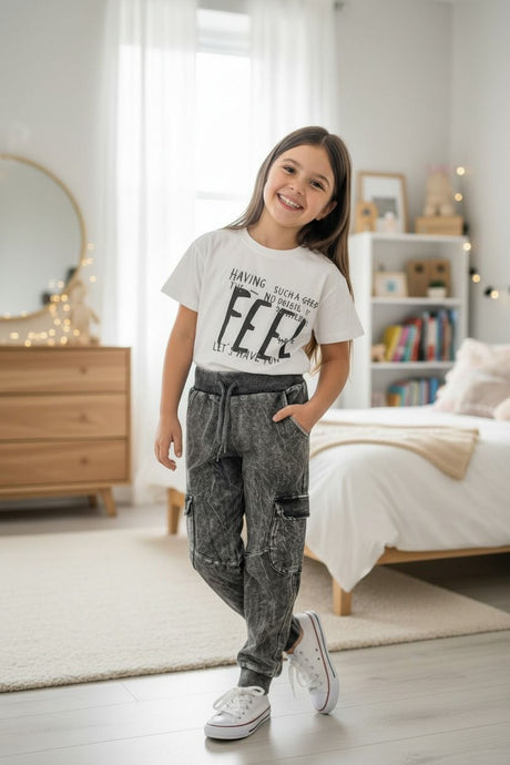 Girl in a white Feel print tee and grey acid wash cargo joggers