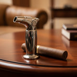 Cigar lighter and unlit cigar on a wooden table with a blurred background