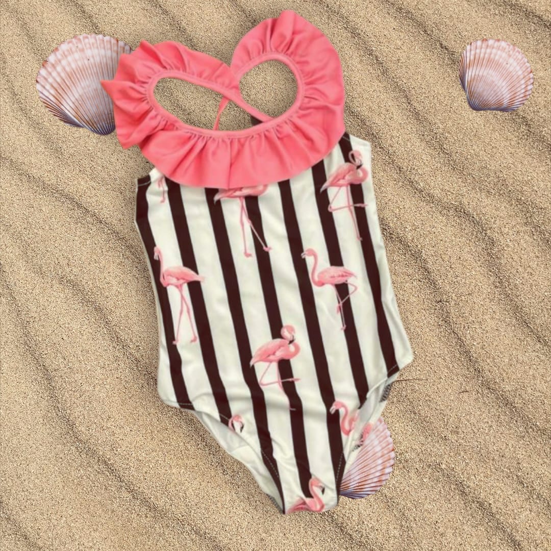 Flamingo print striped onepiece swimsuit flat lay on sand