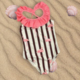 Flamingo print striped onepiece swimsuit flat lay on sand