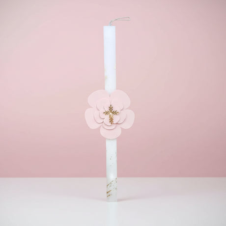 White candle with a pink flower plaque and gold cross