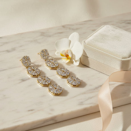 Pair of diamond-studded floral earrings on a marble surface