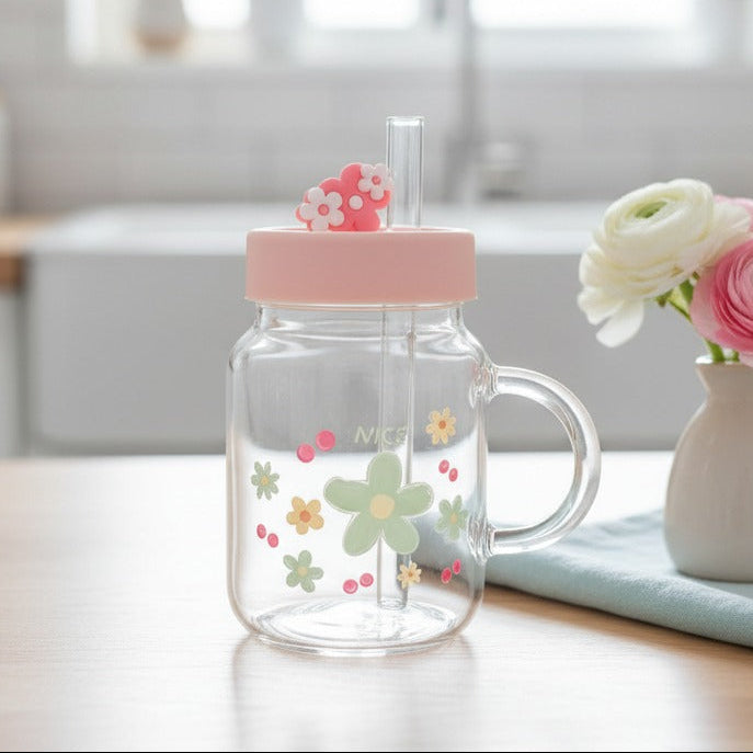 Clear glass mug with a sage green daisy print and a moulded flower lid topper