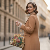 Woman in a brown coat holding a floral handbag on a city street
