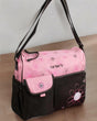 Pink and dark brown changing bag at an angle, showing flap pocket, side bottle pocket and flower stitching