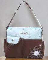 Brown and pale mint changing bag with white daisy embroidery, front flap pocket and long shoulder strap
