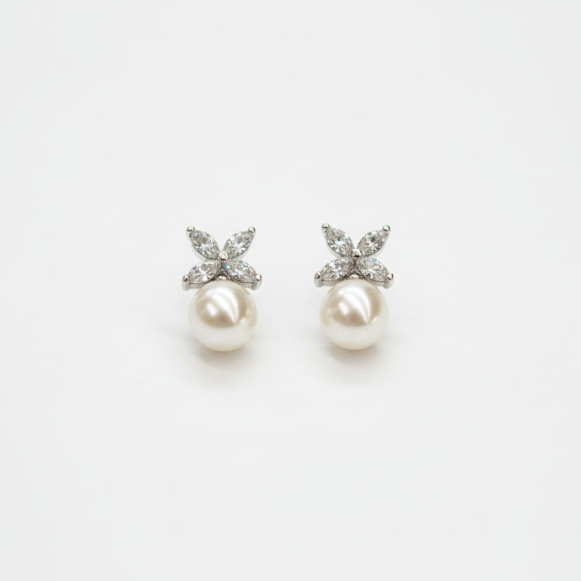 A pair of floral pearl drop earrings on a white background