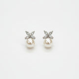 A pair of floral pearl drop earrings on a white background