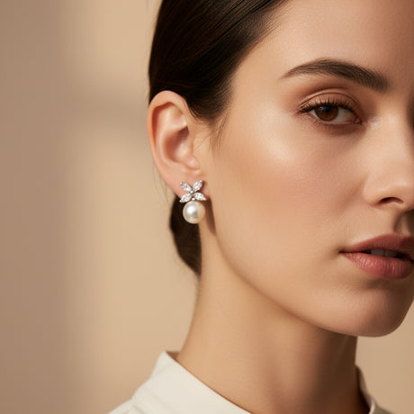 Woman wearing a floral pearl drop earring on a beige background