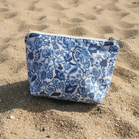Blue floral patterned pouch on sandy ground