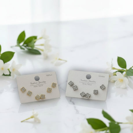 Pair of floral earrings on display cards with a white background and green leaves