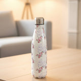 White vacuum flask with lilac ribbon bows and pink rose posies on oak