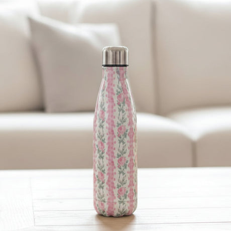 Cream vacuum flask with vertical pink rose stripes on a white wood table