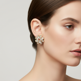 Close-up of a woman wearing a gold decorative flower earring on a neutral background
