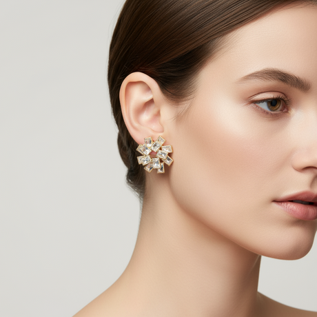 Close-up of a woman wearing a gold decorative flower earring on a neutral background