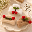 Three fluffy claw clips in white, beige and camel with red felt cherries and green leaves