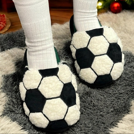 Football slippers worn on a carpeted floor with a Christmas tree in the background