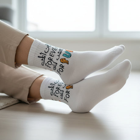 Person wearing white sock with colorful text on a white surface
