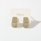 Gold fringe earrings on a 'Fashion' branded card against a beige background