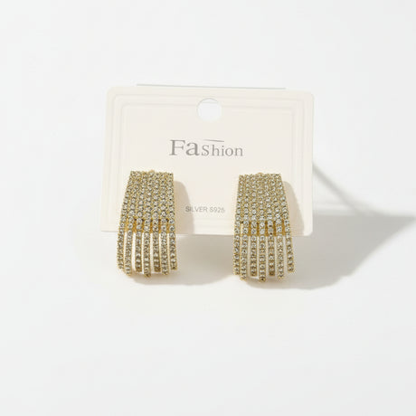 Gold fringe earrings on a 'Fashion' branded card against a beige background